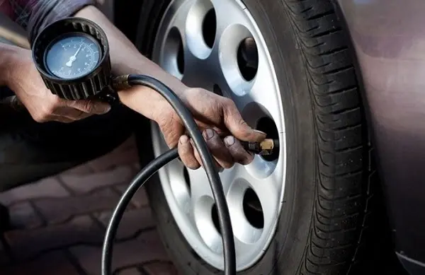 T&agrave;i xế kiểm tra ấp suất lốp trước khi l&aacute;i xe tr&ecirc;n cao tốc v&agrave;o ban đ&ecirc;m